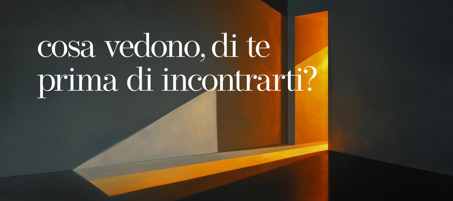 adv01 Una scena pittorica di un interno con una porta socchiusa da cui filtra una luce calda e ambrata in una stanza dai toni scuri e freddi, proiettando un'ombra diagonale netta sulla parete. Il testo recita: "cosa vedono, di te, prima di incontrarti?"
